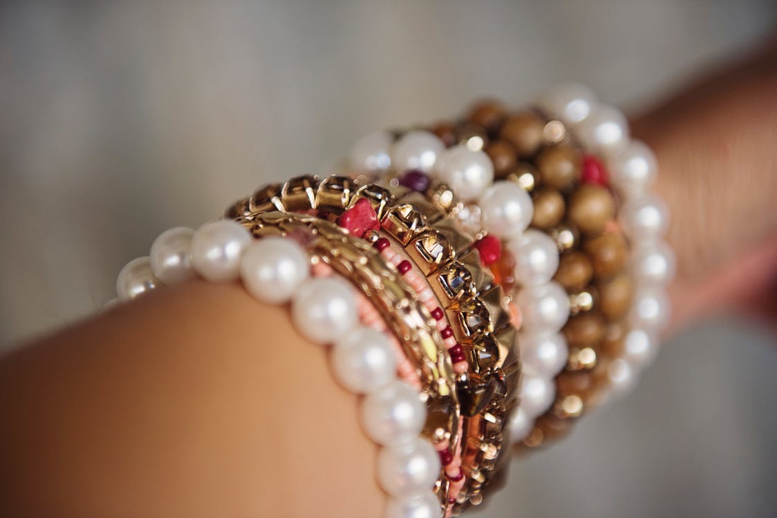 image of gold and pearl bracelets on ladies arm